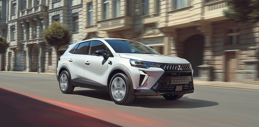 Der Mitsubishi Grandis Ein weißer Mitsubishi Grandis fährt durch die Stadt.