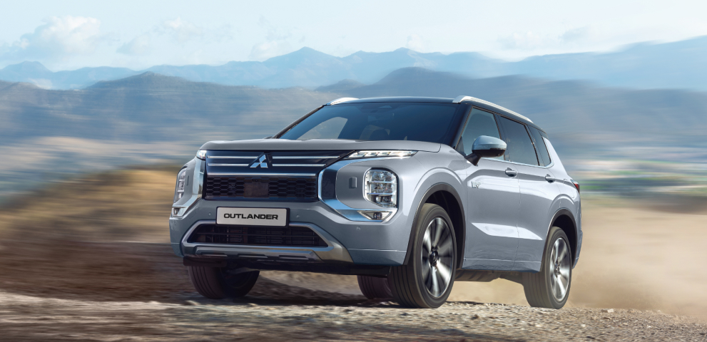 Der Mitsubishi Outlander Ein grauer Mitsubishi Outlander fährt durchs Gelände.