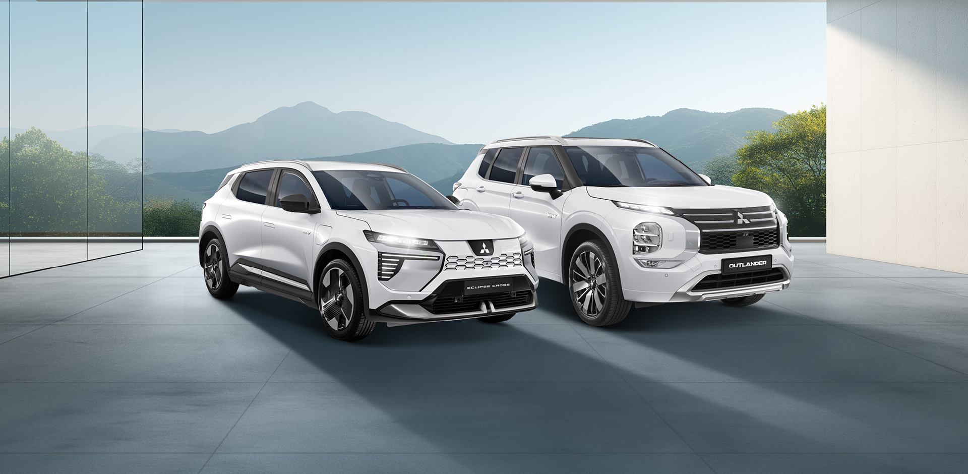 MITSUBISHI MOTORS Elektromobilität Zwei weiße Mitsubishi-SUVs - ein Outlander und ein Eclipse Cross - stehen nebeneinander in einem modernen, lichtdurchfluteten Showroom mit Blick auf eine Berglandschaft.