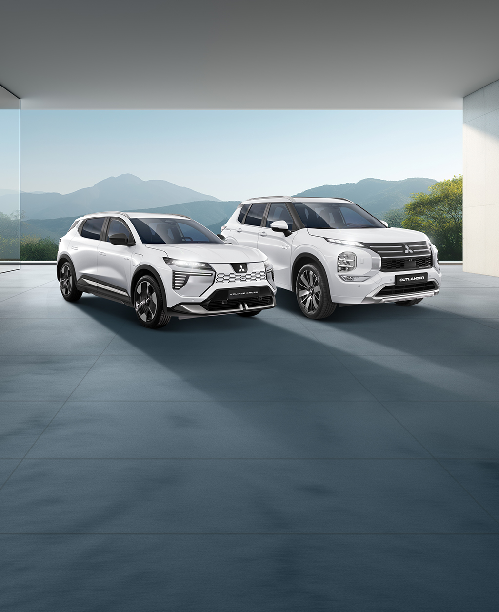 MITSUBISHI MOTORS Elektromobilität Zwei weiße Mitsubishi-SUVs - ein Outlander und ein Eclipse Cross - stehen nebeneinander in einem modernen, lichtdurchfluteten Showroom mit Blick auf eine Berglandschaft.