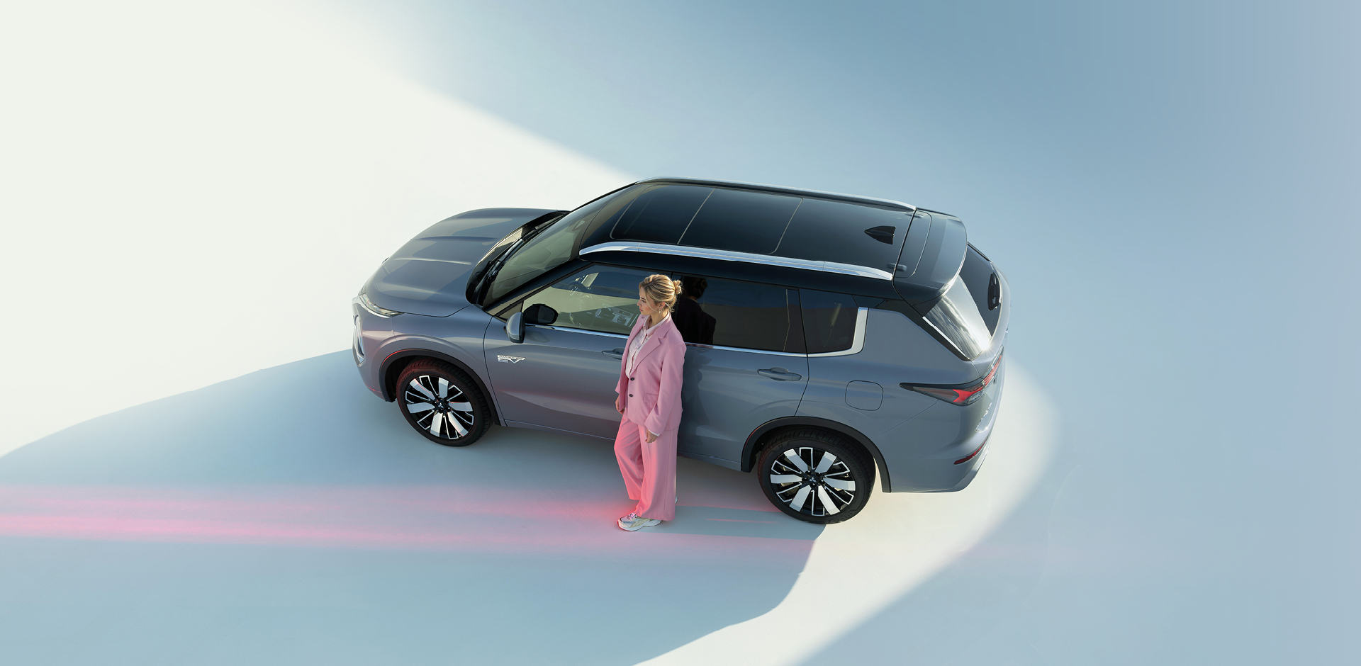 Frau lehnt an der Fahrertür des Outlanders