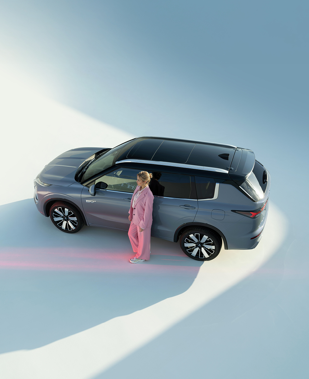 Frau lehnt an der Fahrertür des Outlanders