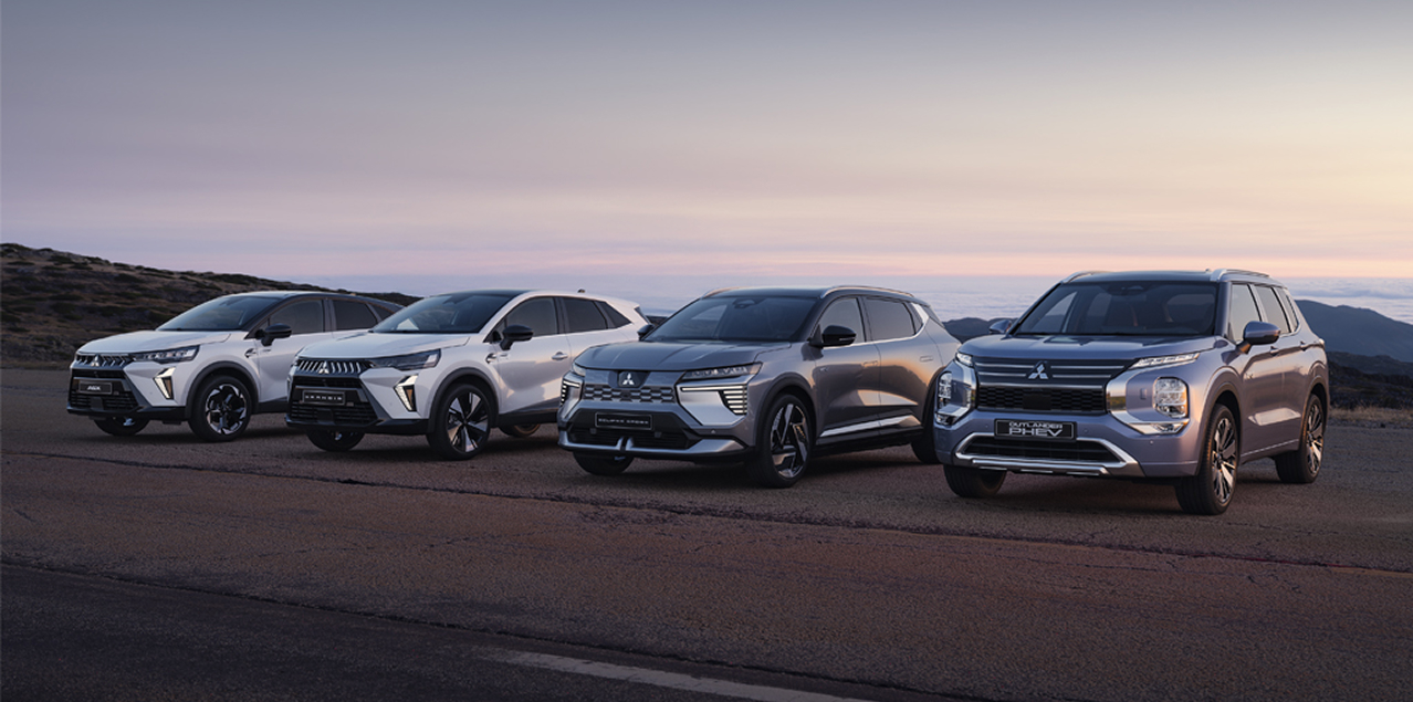 Die Mitsubishi ASX, Grandis, Eclipse Cross und Outlander stehen in der D&auml;mmerung am Stra&szlig;enrand.