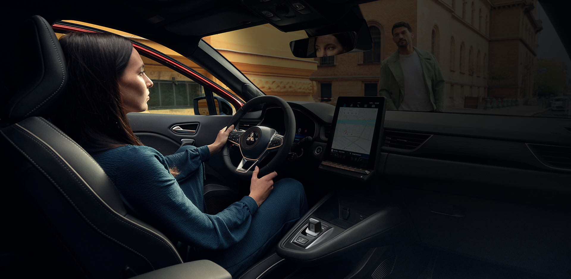 Innenraum eines Mitsubishi ASX: Eine Frau sitzt auf dem Fahrersitz und bedient das Infotainmentsystem, sichtbar sind Armlehne, W&auml;hlhebel und Bedienelemente; im Bild eingeblendete Texte heben Komfortfunktionen wie R&uuml;ckfahrkamera, Lendenwirbelst&uuml;tze, Smart Key System und Klimaautomatik hervor.