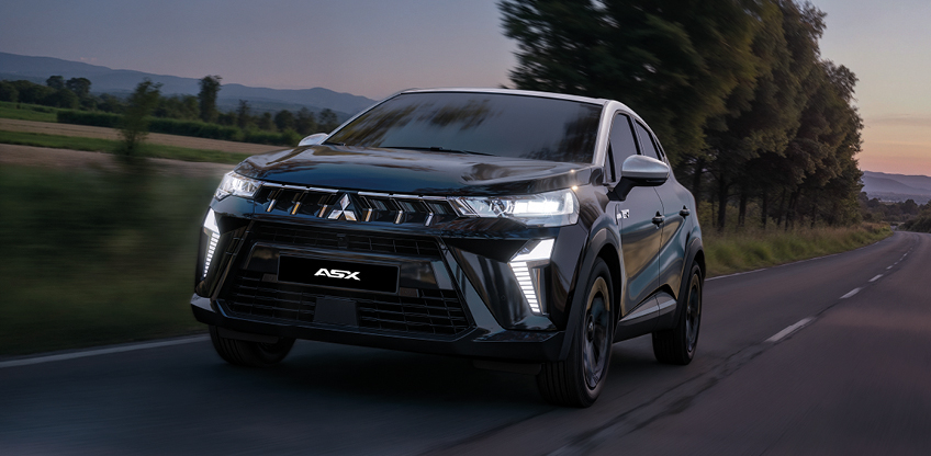 Mitsubishi ASX Black in Fahrt Schwarzer Mitsubishi ASX Black in dynamischer Frontansicht bei Fahrt auf einer Landstraße bei Dämmerung mit eingeschalteten LED-Scheinwerfern