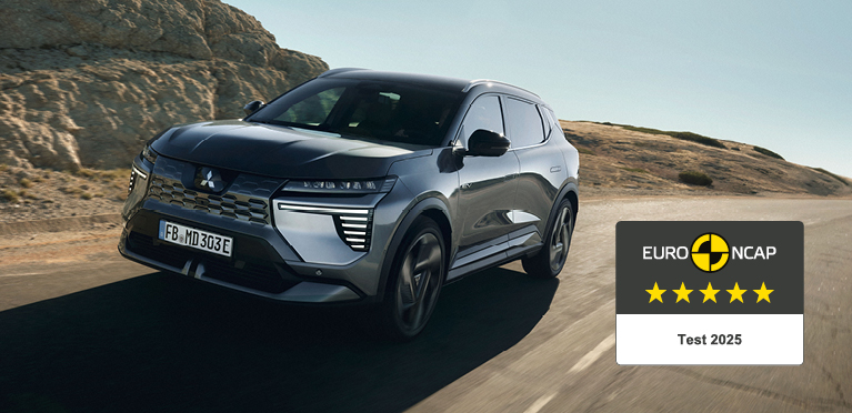 Der neue Mitsubishi Eclipse Cross f&auml;hrt auf der Stra&szlig;e, rechts daneben das 5-Sterne-Euro NCAP-Logo.
