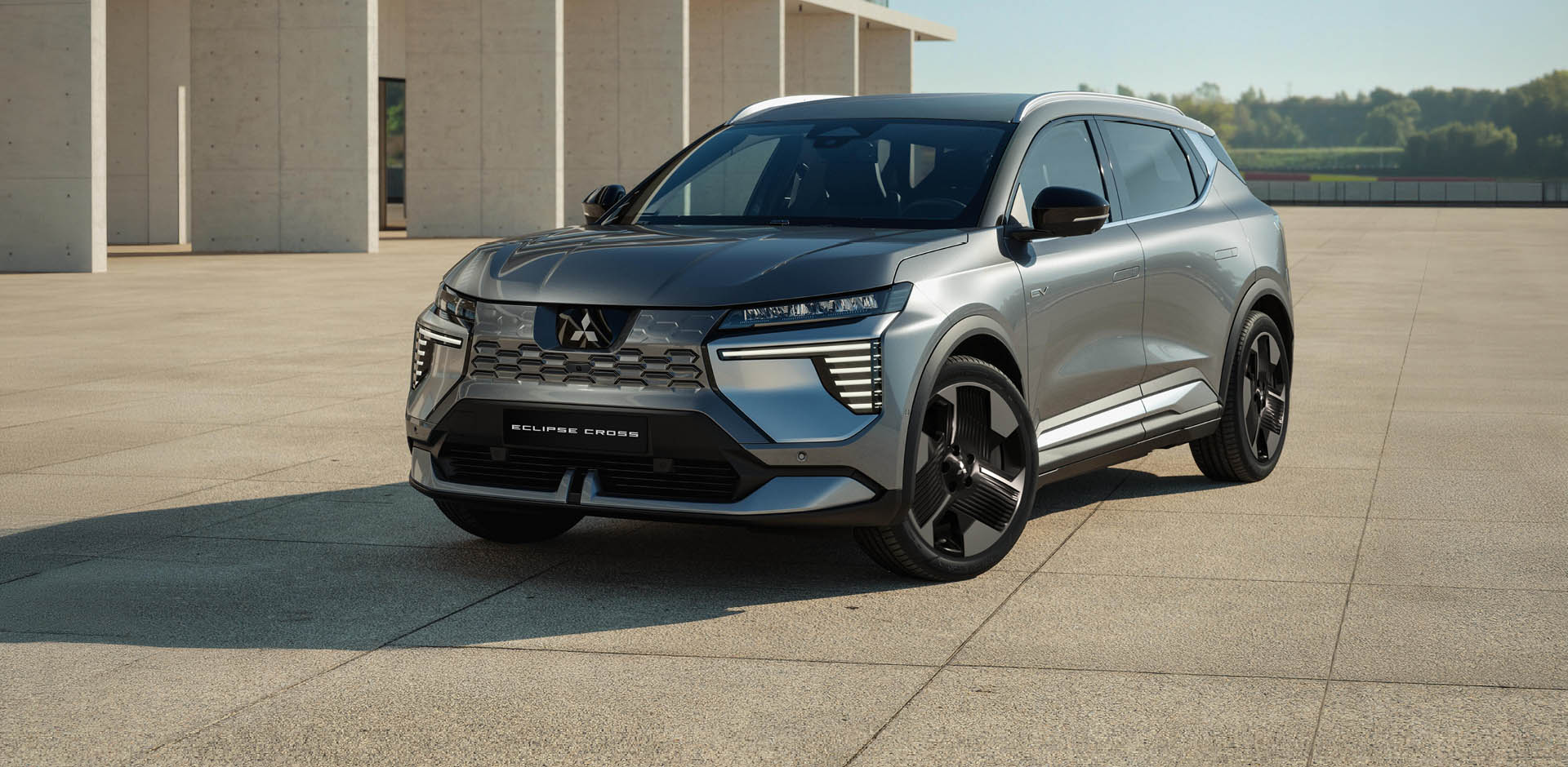 Der Mitsubishi Eclipse Cross steht in einer modernen Umgebung und ist aus der Dreiviertel- Frontalperspektive zu sehen.