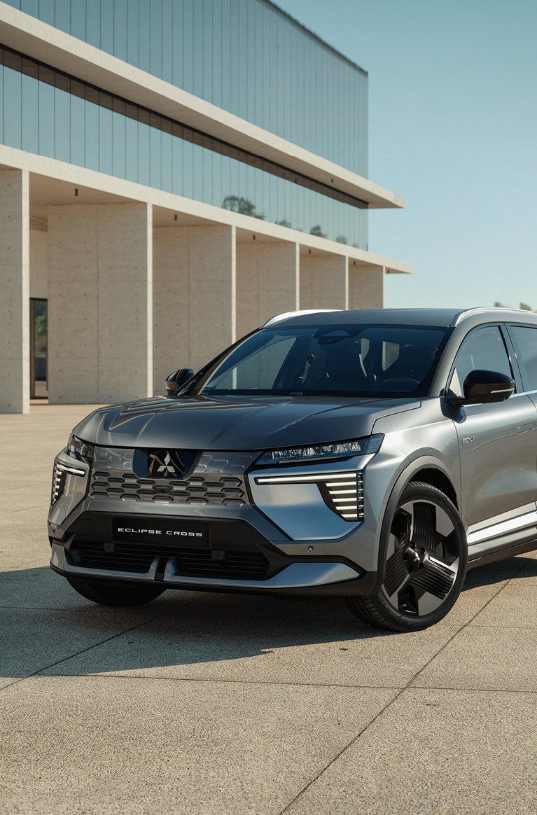 Der Mitsubishi Eclipse Cross steht in einer modernen Umgebung und ist aus der Dreiviertel- Frontalperspektive zu sehen.