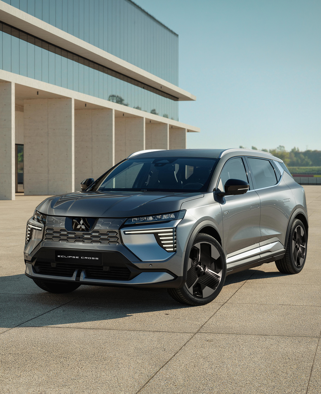 Der Mitsubishi Eclipse Cross steht in einer modernen Umgebung und ist aus der Dreiviertel- Frontalperspektive zu sehen.