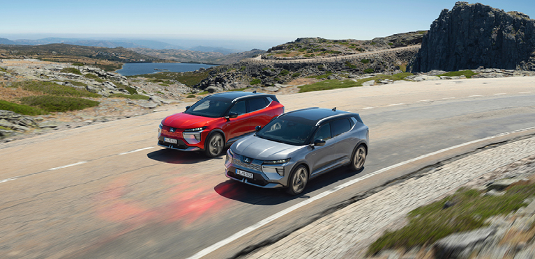 Zwei Mitsubishi Eclipse Cross fahren eine Küstenstraße entlang.