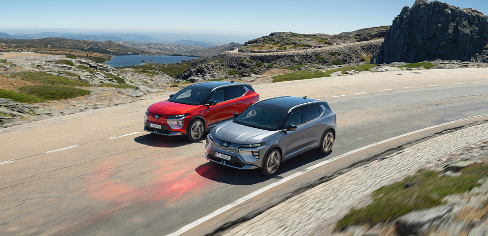 Zwei Mitsubishi Eclipse Cross fahren eine Küstenstraße entlang.