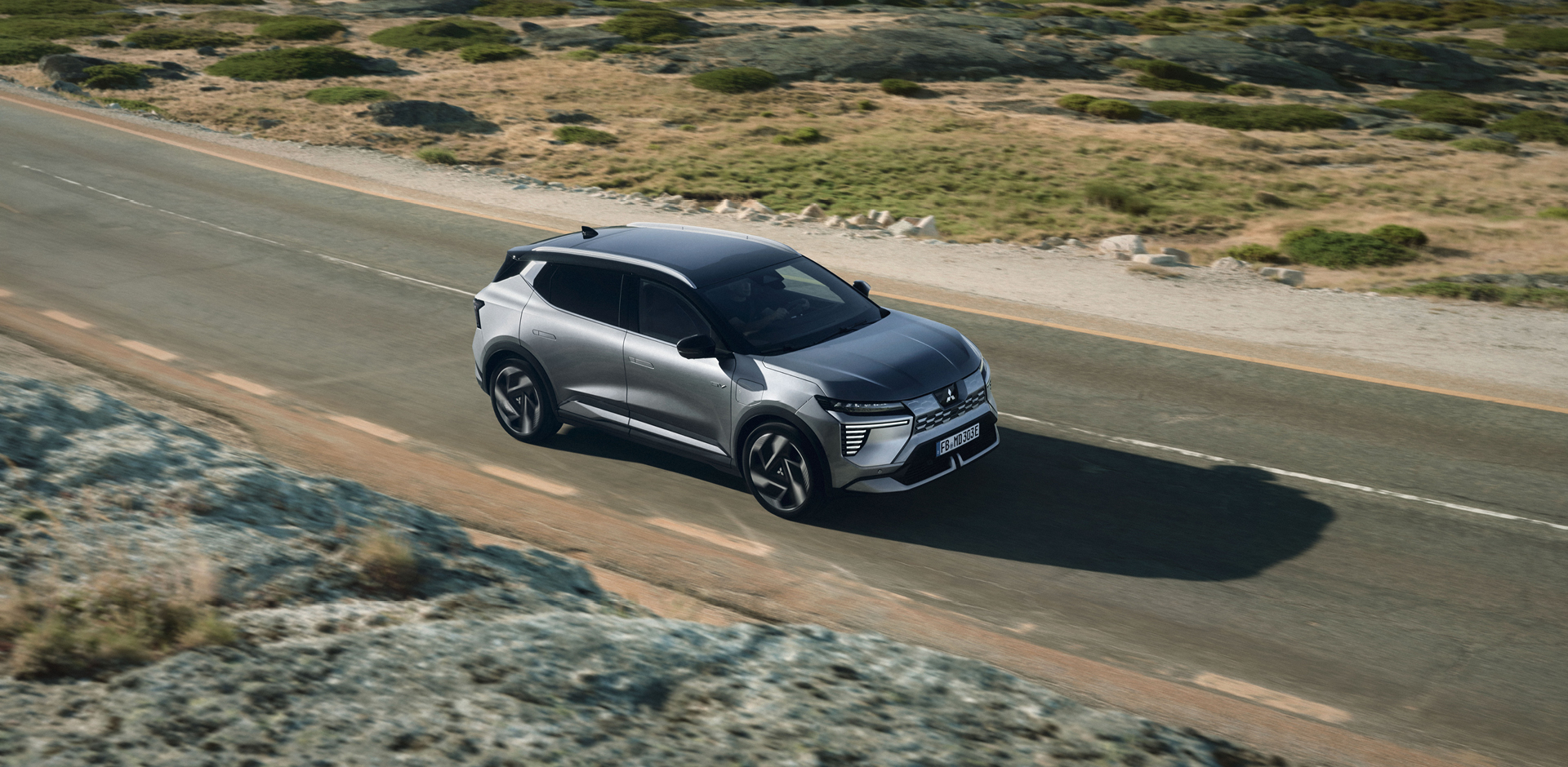 Der neue Mitsubishi Eclipse Cross fährt die Straße entlang.