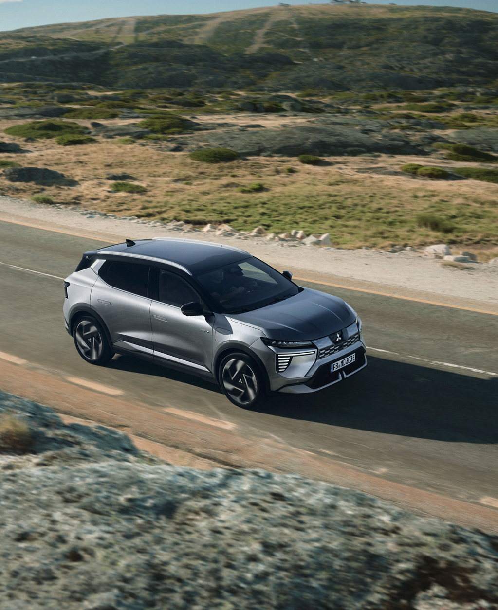 Der neue Mitsubishi Eclipse Cross fährt die Straße entlang.