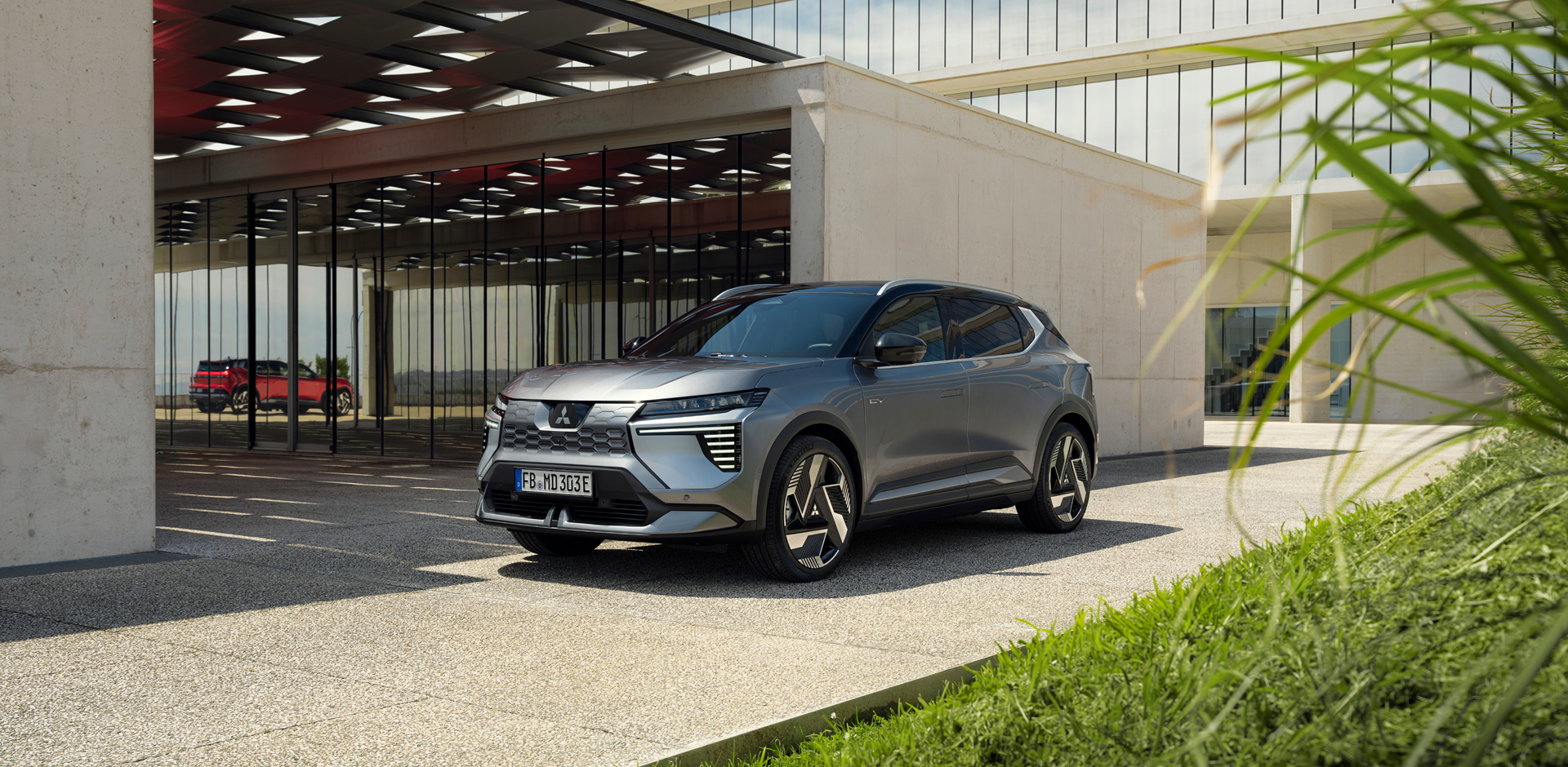 Der neue Mitsubishi Eclipse Cross Der neue Mitsubishi Eclipse Cross steht in einer bepflanzten, modernen Galerie.