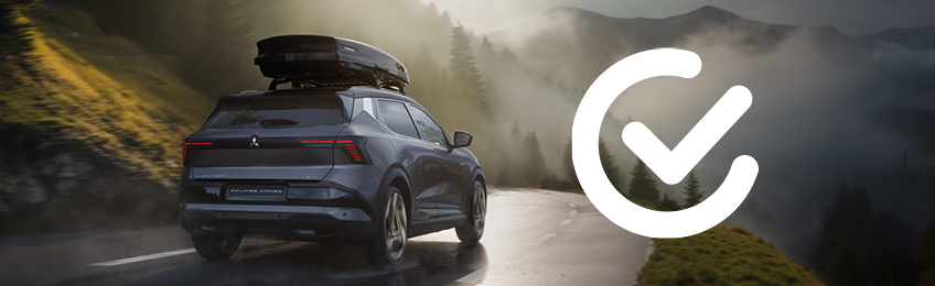 Mitsubishi Eclipse Cross f&auml;hrt auf einer kurvigen Bergstra&szlig;e bei Nebel und Sonnenlicht; rechts im Bild ist ein wei&szlig;es Haken-Icon abgebildet