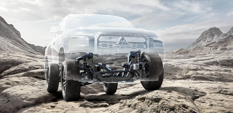 Transparenter Mitsubishi L200 Pick-up mit sichtbar dargestelltem Fahrwerk und Vorderradaufh&auml;ngung auf felsigem Untergrund in einer kargen Berglandschaft unter bew&ouml;lktem Himmel.