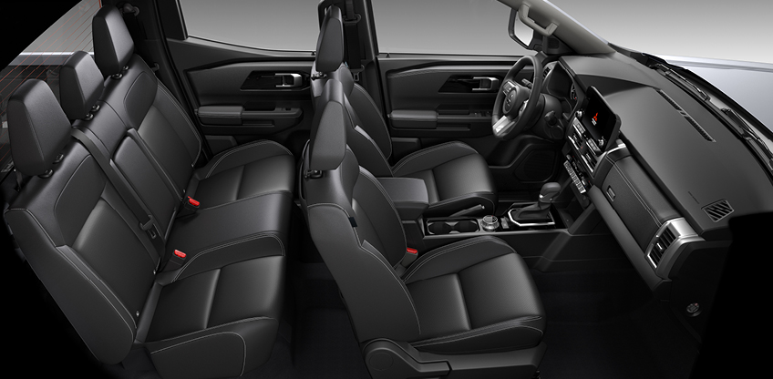 Blick in den schwarzen Innenraum eines Mitsubishi L200 mit drei Sitzreihen, gepolsterten Sitzen, Mittelkonsole mit Automatikschaltung und modernem Armaturenbrett.