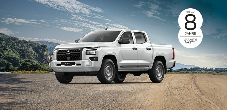 Wei&szlig;er Mitsubishi L200 Pick-up steht auf einer unbefestigten Stra&szlig;e vor einer bergigen Landschaft. Oben rechts ist der Hinweis &bdquo;Bis zu 8 Jahre Garantiepaket***&ldquo; zu sehen.