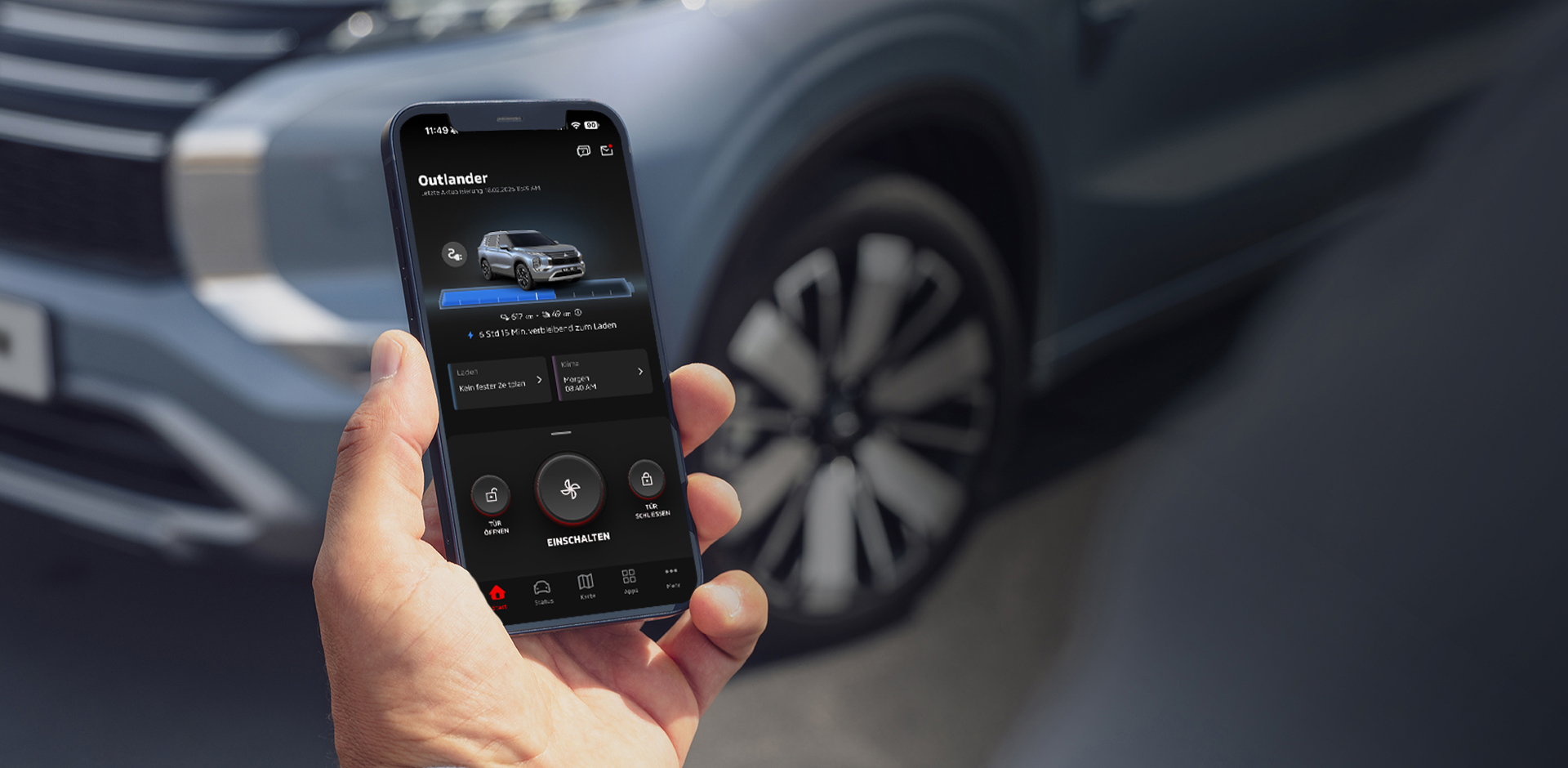 Eine Hand h&auml;lt ein Smartphone mit ge&ouml;ffneter MITSUBISHI MOTORS App, im Hintergrund ist ein Outlander zu sehen.