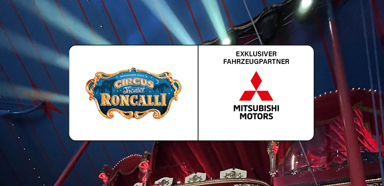Das Kooperationslogo Circus Roncalli und Mitsubishi auf wei&szlig;em Grund, im Hintergrund eine Manege