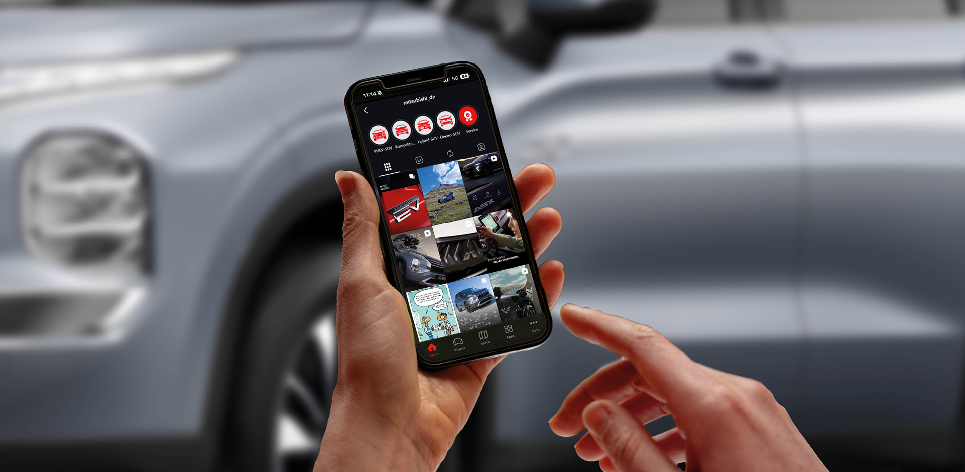 Nahaufnahme eines Smartphones, das das Instagram-Profil von MITSUBISHI MOTORS zeigt, vor dem unscharfen Hintergrund eines Fahrzeugs. 