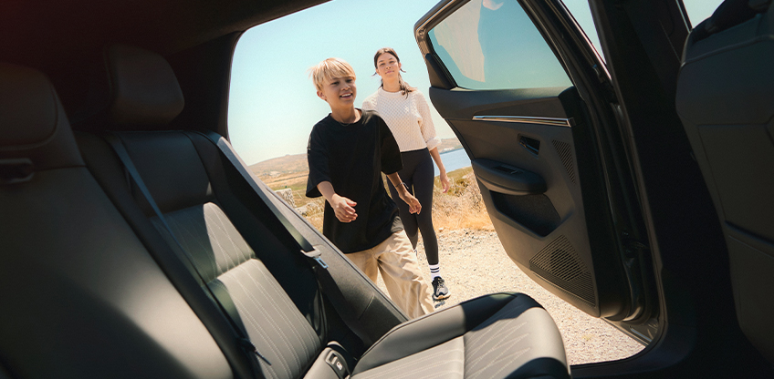 Förderung für Familien E-Prämie 2026 Mutter und Sohn steigen auf der Fahrerseite durch die Hintertür in den Mitsubishi Eclipse Cross.