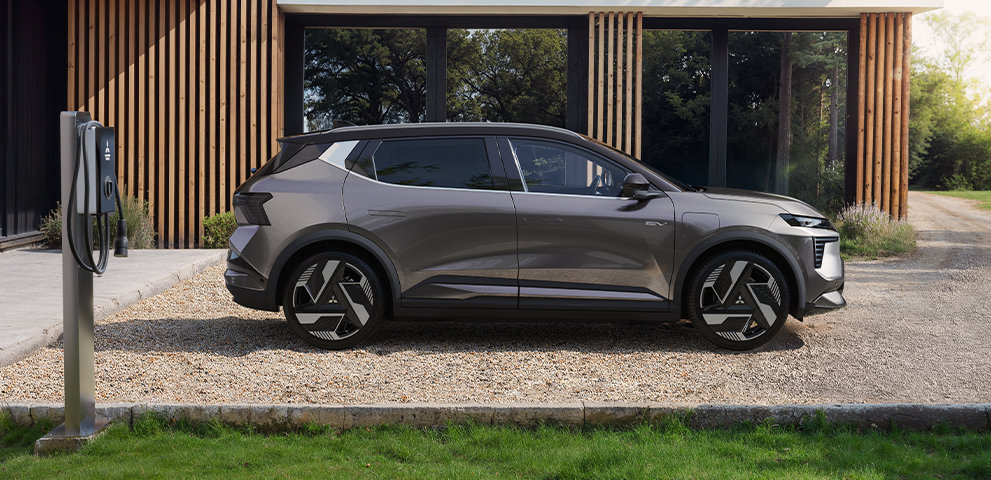 Fahrzeugförderung E-Prämie 2026 Der Mitsubishi Eclipse Cross steht an einer Wallbox vor einem modernen Gebäude.
