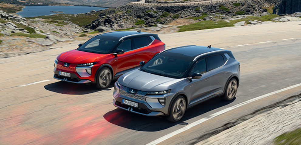 Infotainment Zwei nebeneinander fahrende Eclipse Cross auf ländlicher Straße