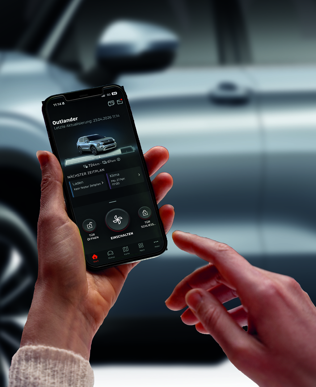 Eine Person h&auml;lt ein Smartphone in der Hand. Auf dem Display ist eine Fahrzeug-App zu sehen, die Informationen wie Reichweite, Ladeplan und Klimasteuerung des Fahrzeugs anzeigt. 