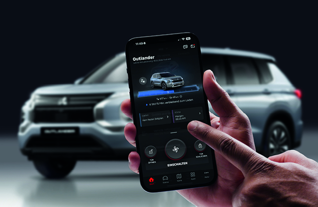 Ein Smartphone wird vor einem parkenden Fahrzeug gehalten. Auf dem Display zeigt die MITSUBISHI MOTORS App den aktuellen Fahrzeugstatus sowie Steuerungsfunktionen wie Klimatisierung und Ladeinformationen, w&auml;hrend eine Hand kurz davor ist, eine Funktion anzutippen.